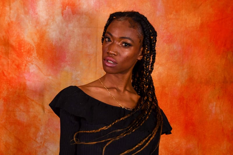 Jennypher, models, Haitian model in black shirt against orange backdrop