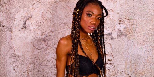 jennypher, models -black model in lingerie in front of concrete backdrop