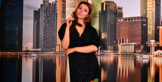 Leah models - redhead model in front of cityscape background in dark dress