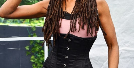 Theresee model in pink shirt and black corset