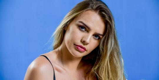 blonde model - Katharine headshot on blue backdrop